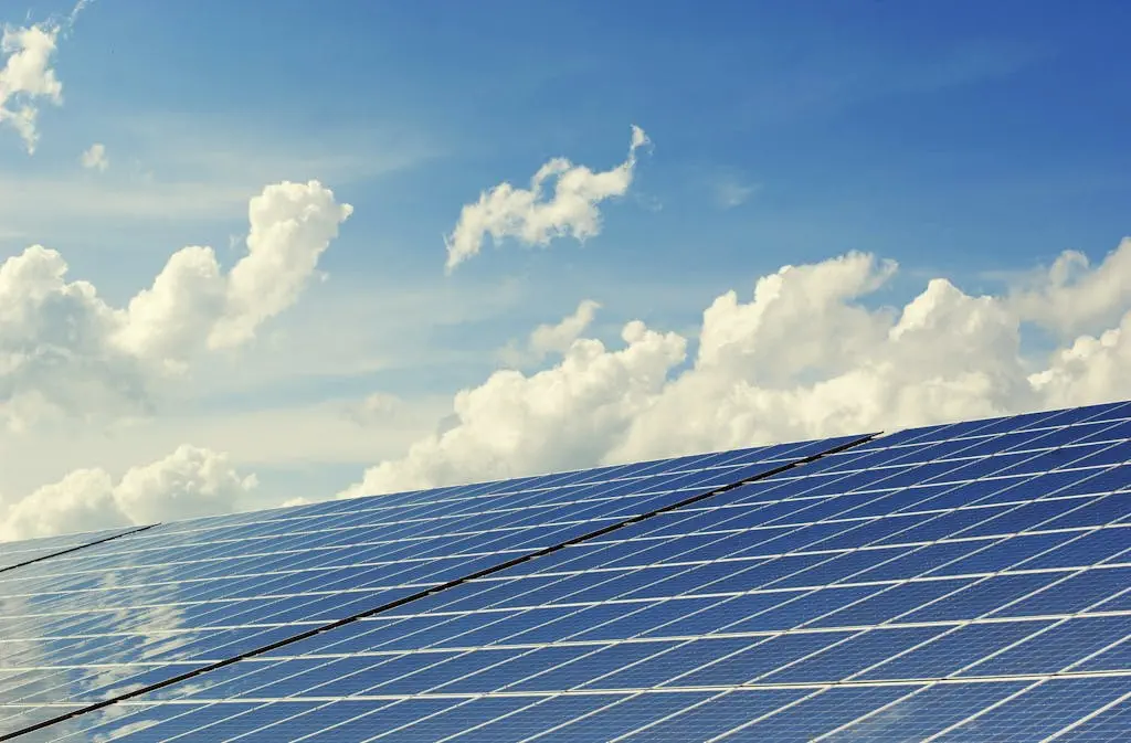 sleek modern solar panels under a vibrant blue sky with clouds symbolizing clean energy. 356036 Sleek modern solar panels under a vibrant blue sky with clouds, symbolizing clean energy.